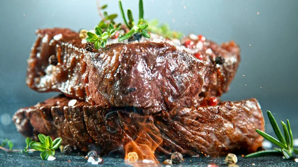 Nahaufnahme von schmackhaftem Rindersteak auf schwarzem Stein-Tisch — Stockfoto