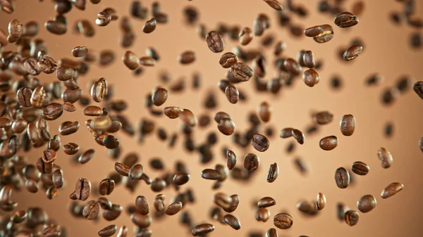 Свежие жареные кофейные зерна летят в воздухе — стоковое фото