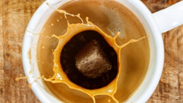 Cubo de azúcar cayendo en una taza de café —  Fotos de Stock