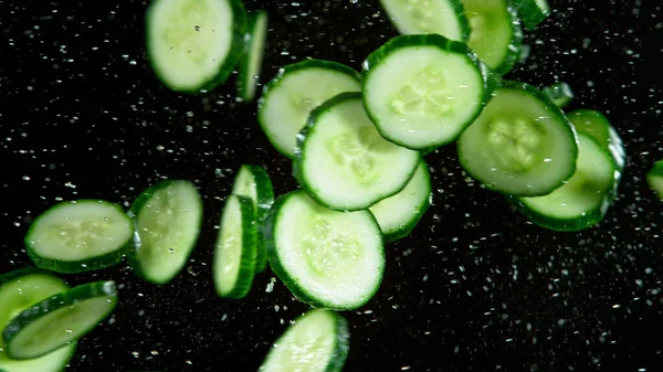 Congelar el movimiento del pepino volador en el aire con salpicaduras de agua — Foto de Stock