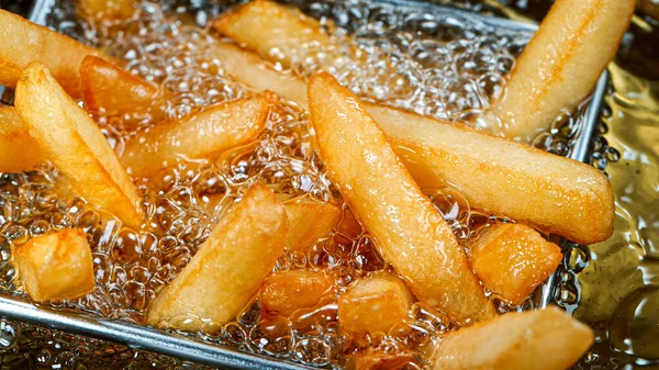 Frites bakken in de frituurpan — Stockfoto