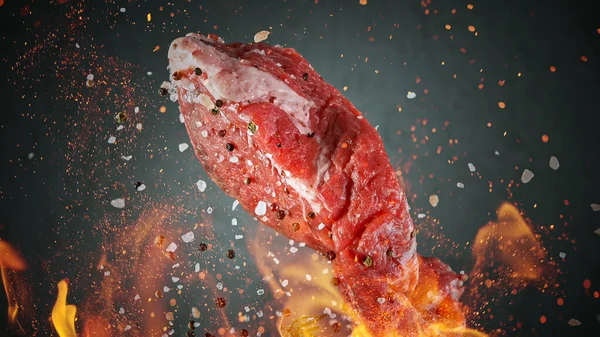 Крупним планом літаючий смачний сирий яловичий стейк на чорному камені — стокове фото