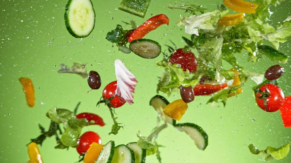 Uçan sebze salatası yeşil arka planda izole edilmiş.. — Stok fotoğraf