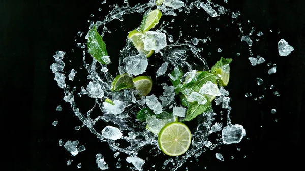 Färska mogna limefrukter flyger på en svart bakgrund. — Stockfoto