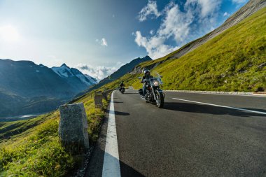 Alplerde motosiklet sürücüsü, açık gökyüzü ile güzel doğa.