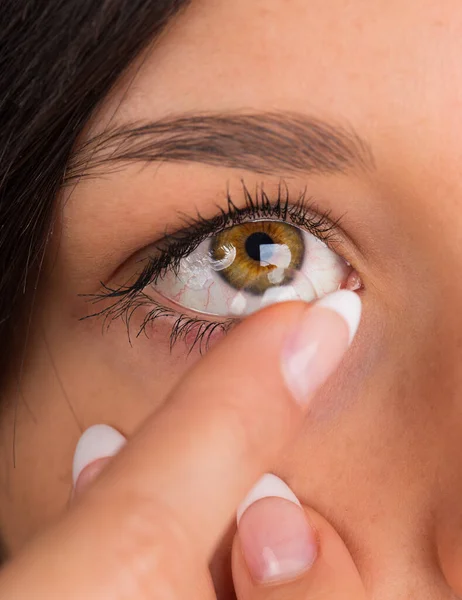 Young woman putting contact lens in her eye. — Stock Photo, Image