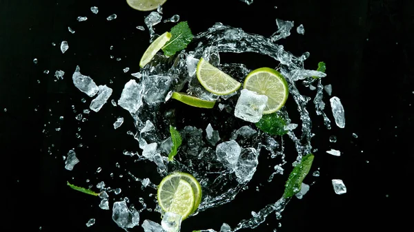 Limes freschi maturi che volano su uno sfondo nero. — Foto Stock