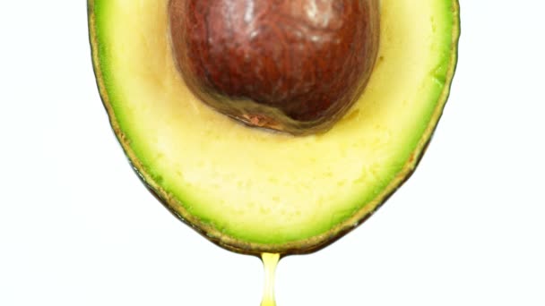 Verse avocado met oliestroom. Concept van gezond fruit ook nuttig in cosmetica. — Stockvideo