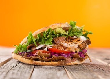 Ahşap zemin üzerinde Türk Donör Kebap Sandviçi.