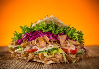 Ahşap zemin üzerinde Türk Donör Kebap Sandviçi.