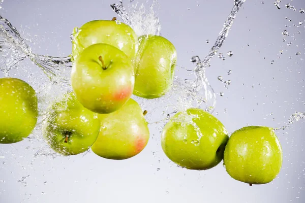 Mrazivý pohyb zelených jablek se stříkající vodou — Stock fotografie