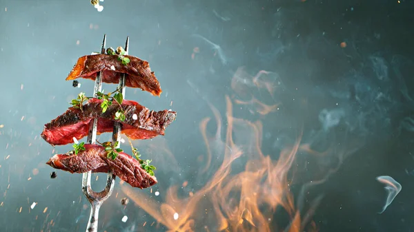 Primer plano de sabroso bistec de ternera en tenedor negro — Foto de Stock