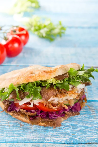 Turkish Doner Kebab Sandwich on wooden background.