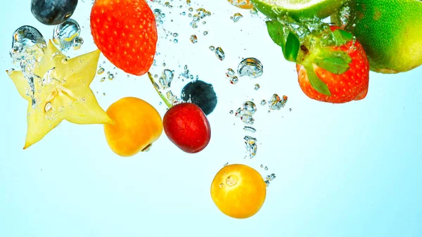 Freeze Motion Shot of Fresh Fruits falling into water — Stock fotografie