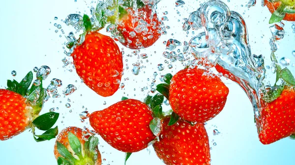 Prise de vue au gel de fraises fraîches tombant dans l'eau — Photo