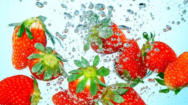 Prise de vue au gel de fraises fraîches tombant dans l'eau — Photo