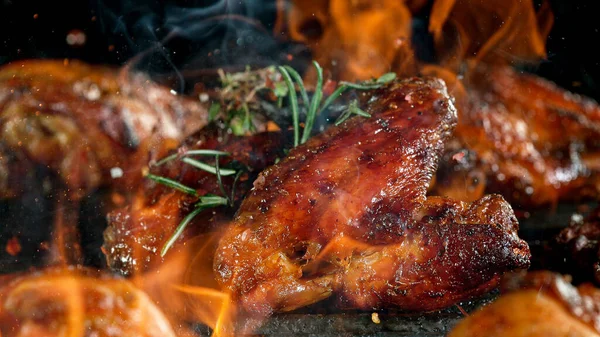 Tasty chicken legs on cast iron grate with fire flames. — Stock Photo, Image