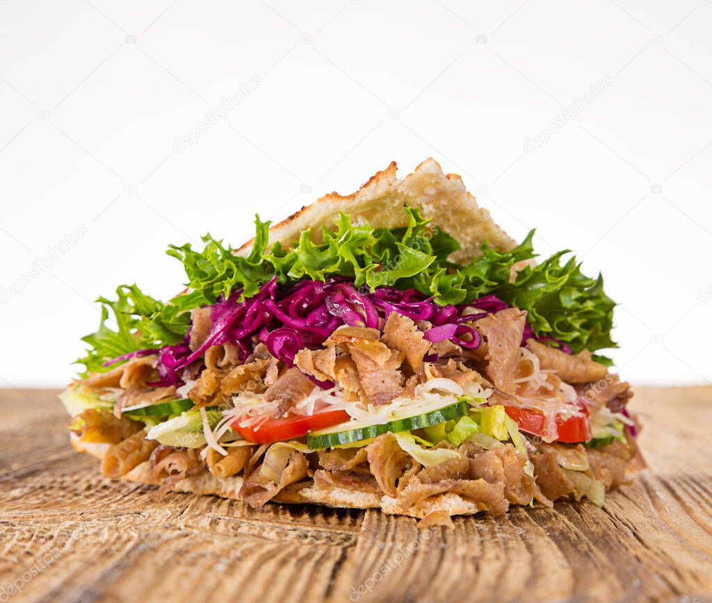 Turkish Doner Kebab Sandwich on wooden background.