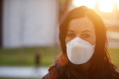 Şehirde enfeksiyona karşı maskeli bir kadın var.