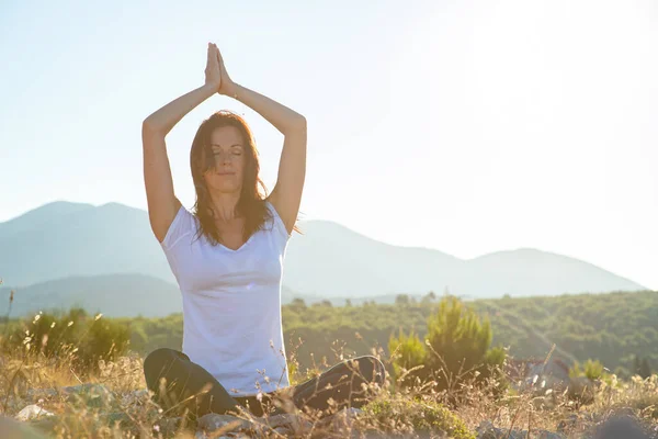Jong fitness vrouw oefenen yoga op berg piek — Stockfoto