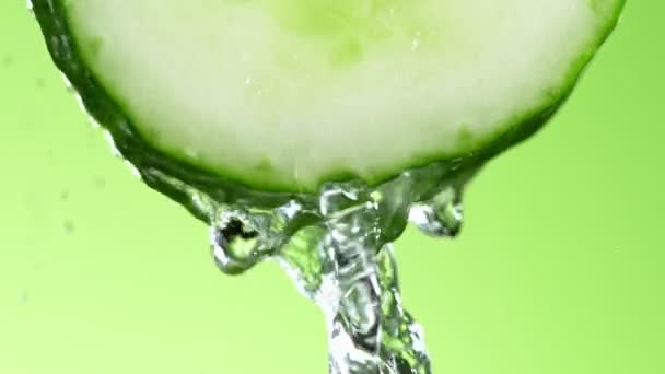 Super Slow Motion Shot van spetterend water op komkommer slice — Stockvideo