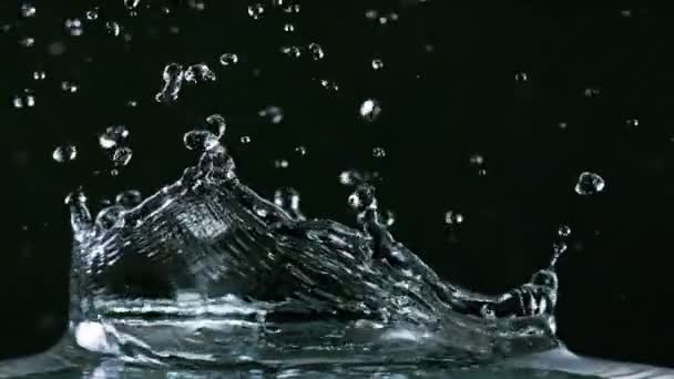 Voda stříkající na černém pozadí, super zpomalený pohyb. — Stock video