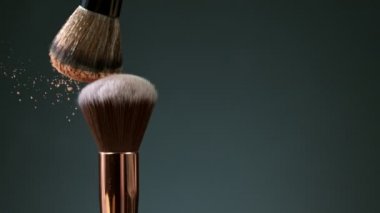 Makyaj fırçaları koyu arkaplanda birbirine dokunur