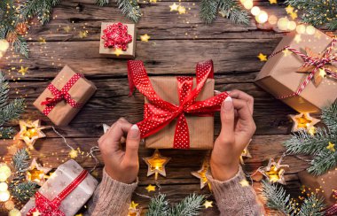 Kadın eli ve hediye kutusunun üst görüntüsü.