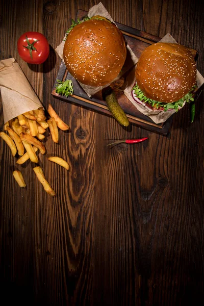 Sabrosas hamburguesas en la mesa de madera vintage, vista superior. — Foto de Stock