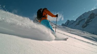 Manzaralı Dolomitler dağlarında kayakçı taze toz karda kayıyor. 1000 fp 'de süper yavaş çekim..
