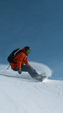 Güneşli bir günde kar kaykayı sürücüsü taze toz altında, Alp manzaralı. 1000 fp 'de süper yavaş çekim..