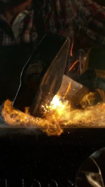 Demirciye yakın plan örsün üzerinde kızgın demirden uçan kıvılcımlar dövüyor. Süper yavaş çekim, 1000 fps hızla yüksek hızlı sinema kamerasıyla çekildi.