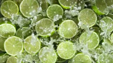 Super Slow Motion Shot of Fresh Limes Falling into Water at 1000 fps