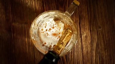 Super Slow Motion of Pouring Beer into Pint Glass, Top Down View, Rotating Camera Move. Filmed on High Speed Cinema Camera, 1000 fps.