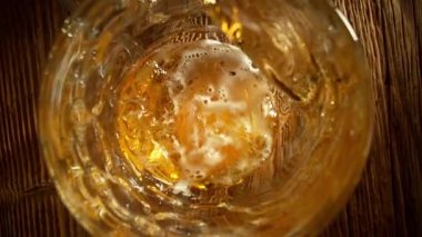 Super Slow Motion of Pouring Beer into Pint Glass, Top Down View, Camera Move. Filmed on High Speed Cinema Camera, 1000 fps.