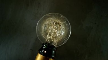 Kameranın hareketinin çok yavaş bir şekilde şampanya kadehine dönüşmesi. Su altı makro mercekli eşsiz bir açı. Kutlama ve başarı kavramı. Yüksek hızlı sinema kamerası, 1000 fps.