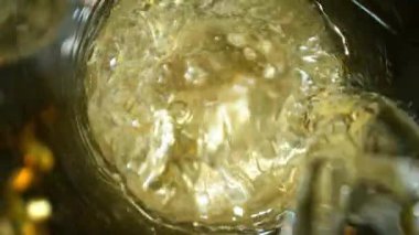 Kameranın hareketinin çok yavaş bir şekilde şampanya kadehine dönüşmesi. Su altı makro mercekli eşsiz bir açı. Kutlama ve başarı kavramı. Yüksek hızlı sinema kamerası, 1000 fps.