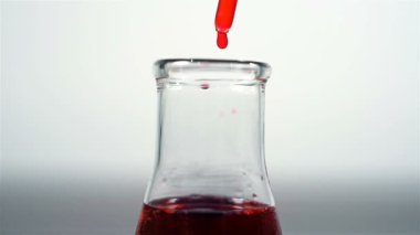 Tüp bebek için kırmızı kimyasal sıvı bırakarak bir bilim adamı. Tıbbi araştırma kavramı