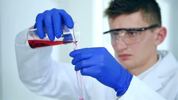 Labormitarbeiter Mantel Und Schutzbrille Gießt Probe Ins Reagenzglas Zeitlupeneffekt — Stockvideo