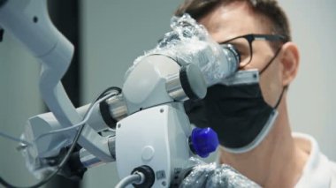 Dental ofis Içinde Kamera Ile mikroskop kullanan dişçi. Yakın çekim