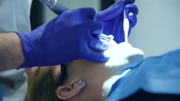 歯科医院でアシスタントを持つ歯科医外科医が医療手術を行う — ストック動画
