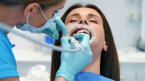 牙科诊所的牙医和助理安装支架给病人 — 图库视频影像