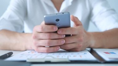 Ofiste oturan ve cep telefonu kullanan bir iş adamı. Yatırım ve Finansal Konsept. Kapat.