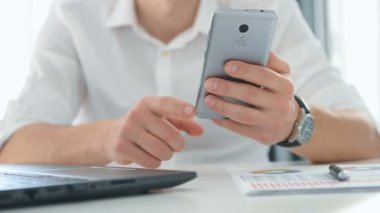 İş adamı cep telefonundan iş raporlarını kontrol ediyor. İş ve Mali Başarı Konsepti. Yavaş Hareket Efekti.