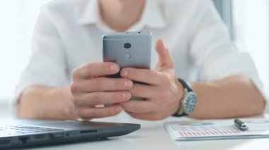 Muhasebeci cep telefonundan iş raporlarını kontrol ediyor. İş ve Mali Başarı Konsepti. Yavaş Hareket Efekti.