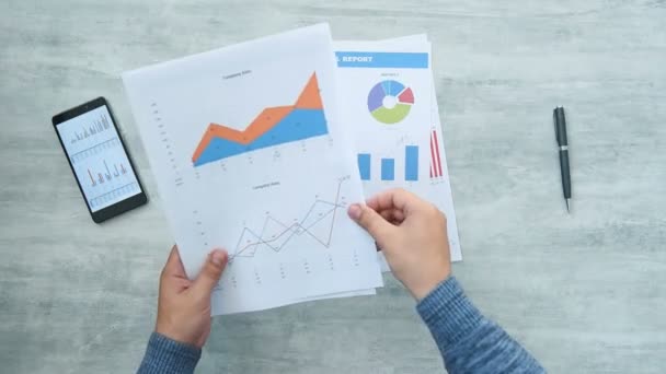 Geschäftsmann Analysiert Diagramme Und Diagramme Auf Dem Holztisch Finanz Und — Stockvideo