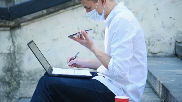 Affärsman Medicinsk Mask Talar Mobiltelefon Och Sitter Utomhus Pandemi Covid — Stockvideo