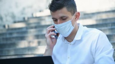 Maskeli İşadamı dışarıda çalışıyor ve telefonda konuşuyor. Pandemia Kapsamlı Kavram