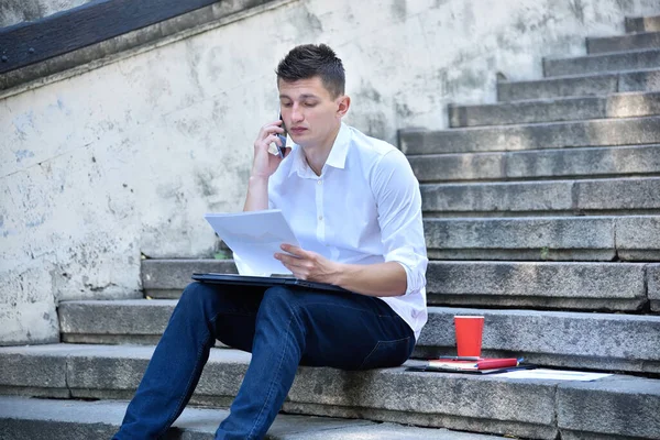 Νεαρός Επιχειρηματίας Κάθεται Στις Σκάλες Και Μιλάει Συνάδελφο Στο Τηλέφωνο — Φωτογραφία Αρχείου