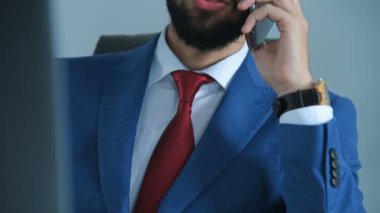 Ofiste cep telefonuyla konuşan genç bir iş adamı. Meslek ve İşçi Konsepti. Yavaş Hareket Efekti